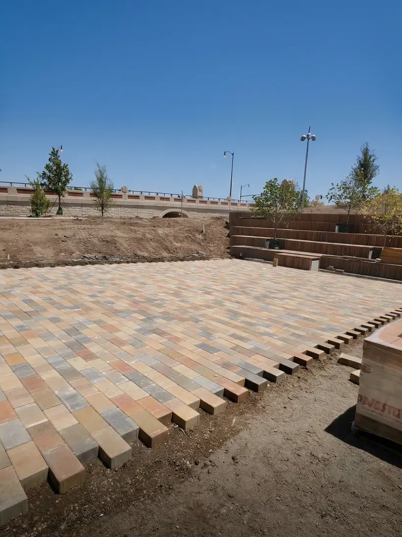 Terraza de adoqu&iacute;n a la hora dorada con camas plantadas y bancas