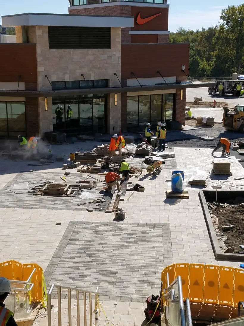 Cuadrilla pavimentando junto a edificio comercial